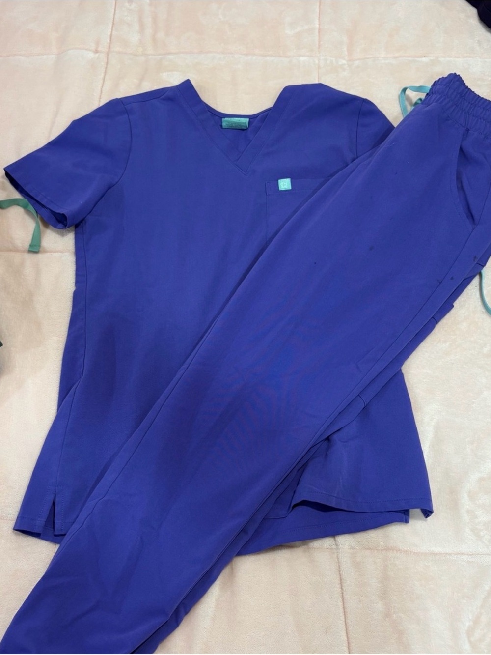 Purple garde malade scrub with some crayon marks on the pants